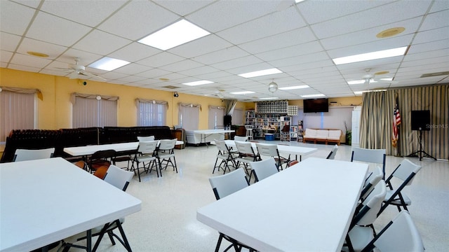 dining space featuring a drop ceiling and ceiling fan