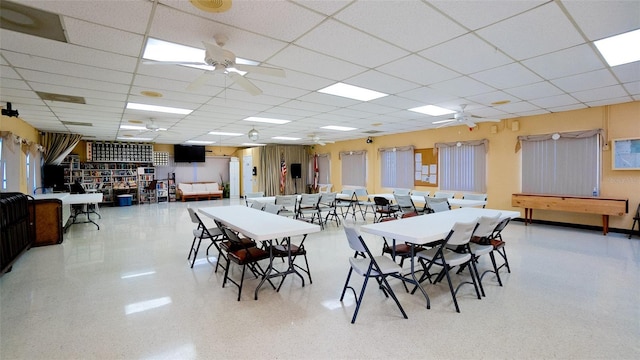 dining space with a paneled ceiling and ceiling fan