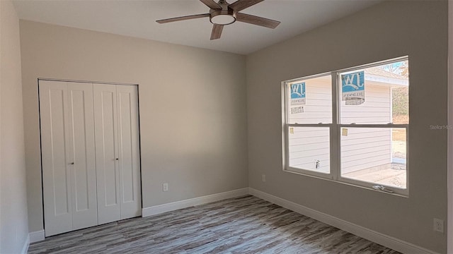 unfurnished bedroom featuring wood-type flooring, ceiling fan, and a closet