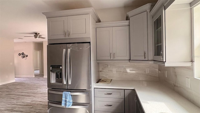 kitchen featuring decorative backsplash, ceiling fan, and stainless steel fridge with ice dispenser