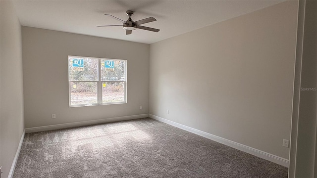 carpeted spare room featuring ceiling fan