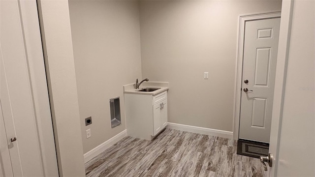 clothes washing area with sink, cabinets, light hardwood / wood-style floors, and hookup for an electric dryer