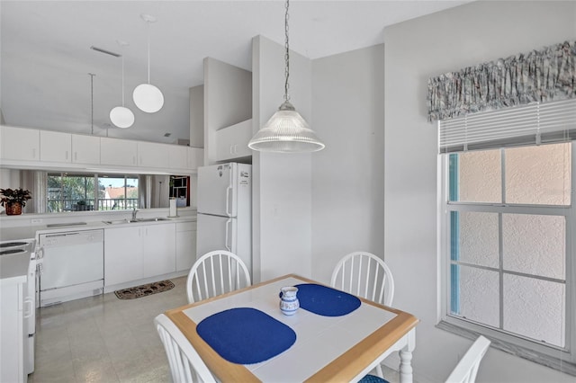 dining area featuring sink and a towering ceiling