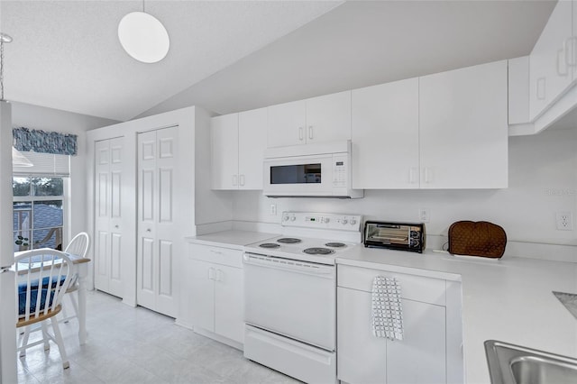 kitchen featuring vaulted ceiling, decorative light fixtures, white cabinets, white appliances, and a textured ceiling