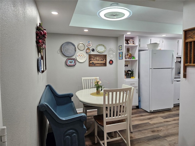 dining area with wood finished floors and recessed lighting