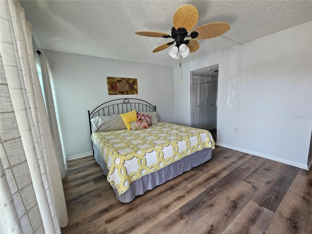 bedroom with ceiling fan, a textured ceiling, baseboards, and wood finished floors