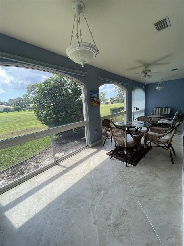 sunroom featuring ceiling fan