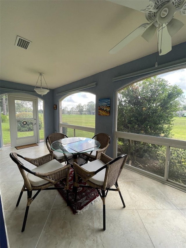 sunroom / solarium featuring ceiling fan