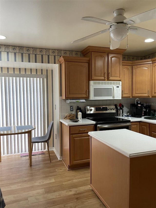 kitchen with light hardwood / wood-style flooring, decorative backsplash, ceiling fan, and stainless steel electric range