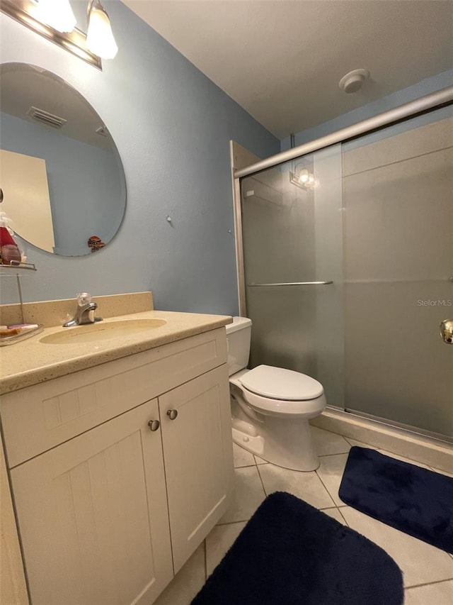 bathroom with vanity, tile patterned floors, toilet, and walk in shower