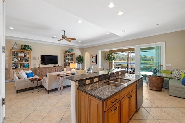 kitchen featuring sink, stainless steel dishwasher, light tile patterned floors, and dark stone counters