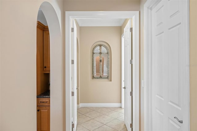 corridor with light tile patterned floors and ornamental molding