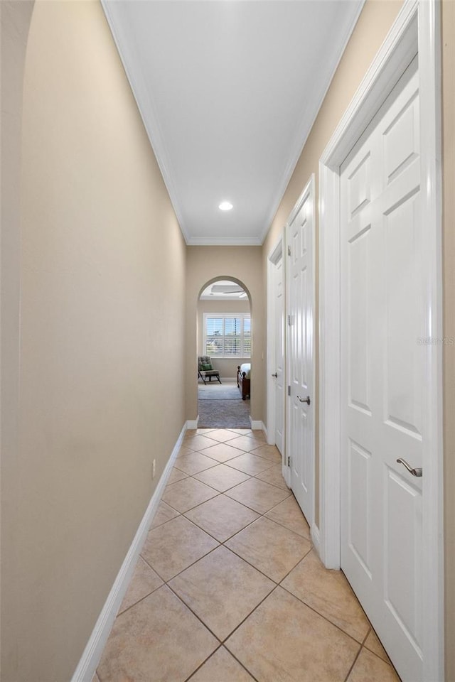 hallway featuring ornamental molding and light tile patterned floors