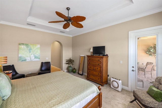 carpeted bedroom featuring crown molding, ceiling fan, and a tray ceiling