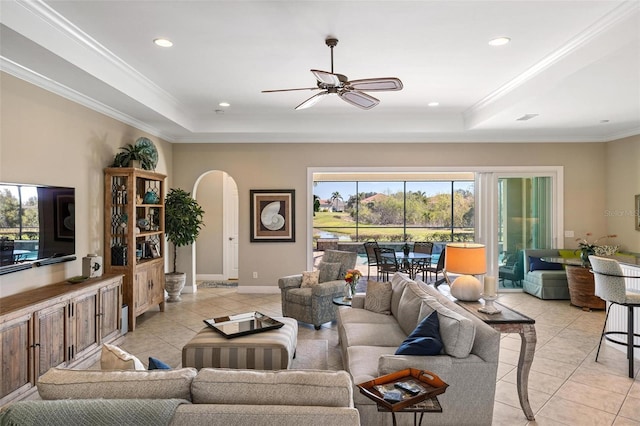 living room featuring a raised ceiling, crown molding, and light tile patterned floors