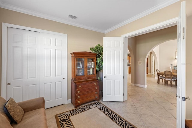 sitting room featuring crown molding and light tile patterned floors