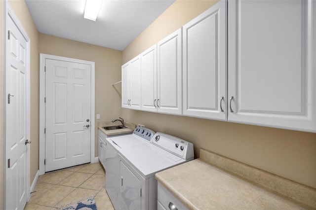 laundry room with cabinets, light tile patterned flooring, sink, and washing machine and clothes dryer