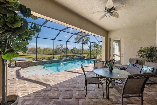 view of pool featuring a lanai, a patio, ceiling fan, and a water view