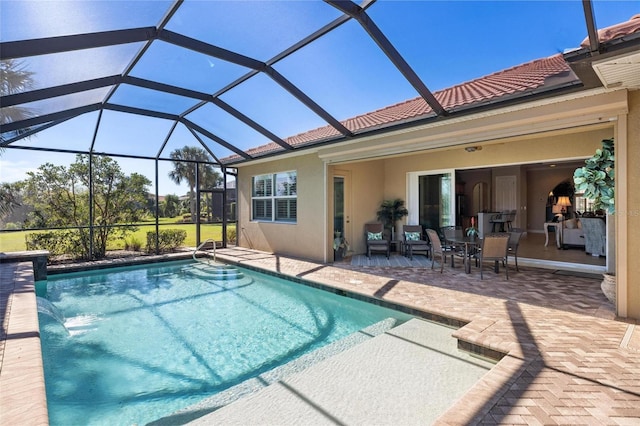 view of pool with a lanai, a patio area, and pool water feature