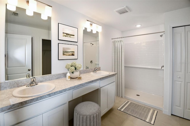 bathroom featuring vanity, tile patterned flooring, and walk in shower