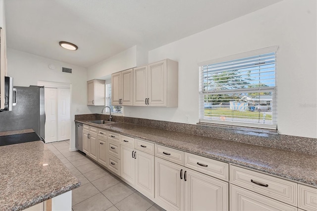 kitchen featuring appliances with stainless steel finishes, sink, and light tile patterned floors