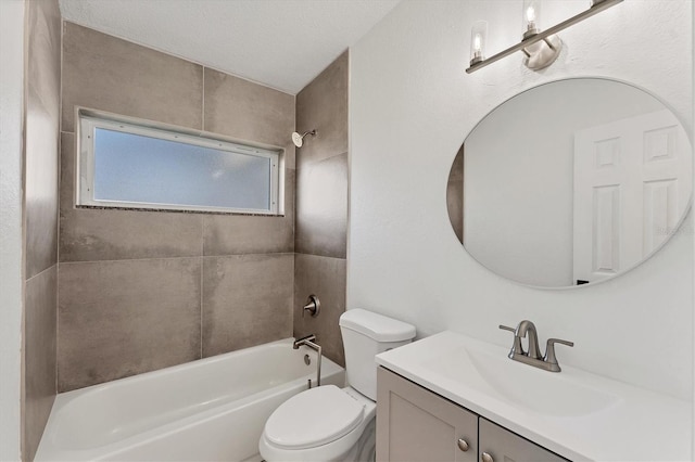 full bathroom featuring vanity, a textured ceiling, toilet, and tiled shower / bath