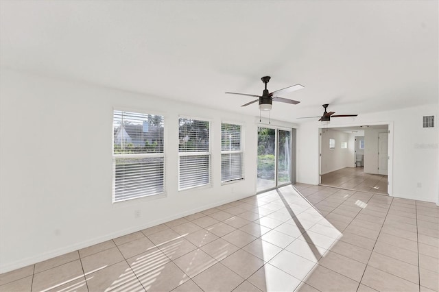 tiled spare room with a wealth of natural light and ceiling fan