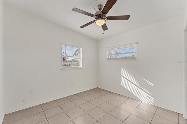 tiled spare room featuring ceiling fan