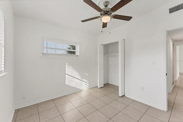 unfurnished bedroom featuring light tile patterned flooring, ceiling fan, and a closet