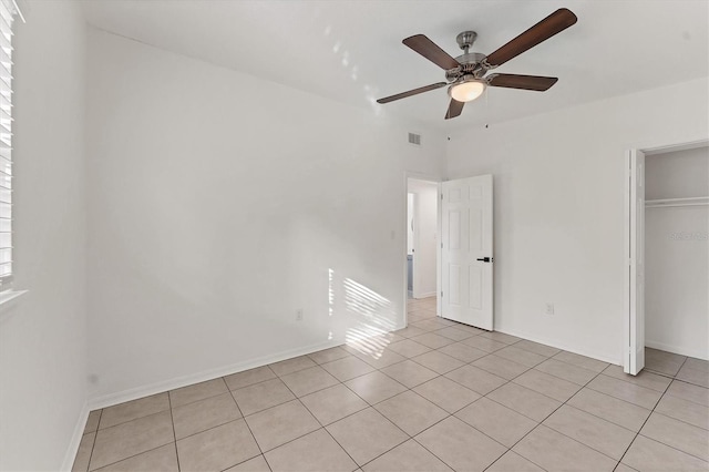 unfurnished bedroom with light tile patterned floors, a closet, and ceiling fan