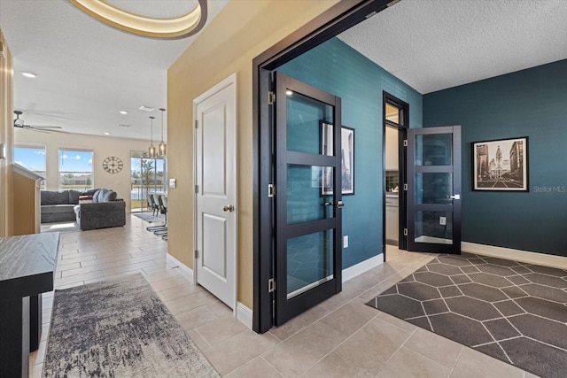 corridor with an inviting chandelier and a textured ceiling