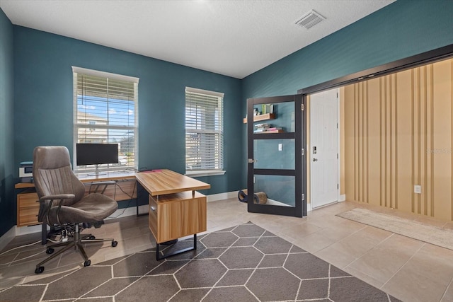 home office with tile patterned flooring and a textured ceiling