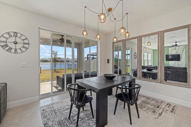 dining space featuring a water view, ceiling fan with notable chandelier, and light tile patterned floors