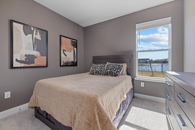 carpeted bedroom featuring a water view