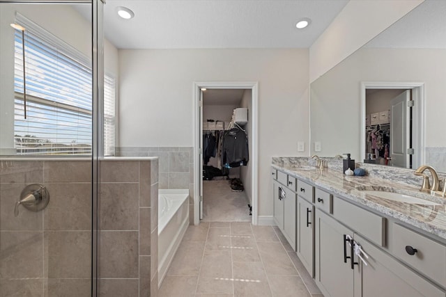 bathroom with tile patterned floors, vanity, and a bath