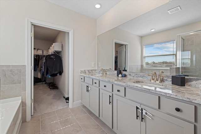 bathroom with vanity, tile patterned flooring, and a tub