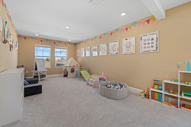 recreation room featuring beam ceiling and carpet