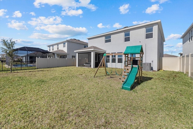 rear view of house featuring a gazebo, central AC unit, a playground, and a lawn