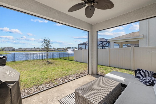 sunroom with a water view and ceiling fan