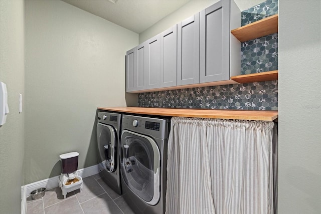 laundry room featuring light tile patterned floors, cabinets, and independent washer and dryer