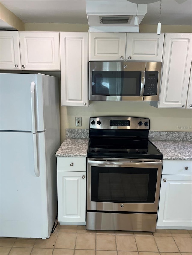 kitchen featuring white cabinetry, stainless steel appliances, and light tile patterned flooring