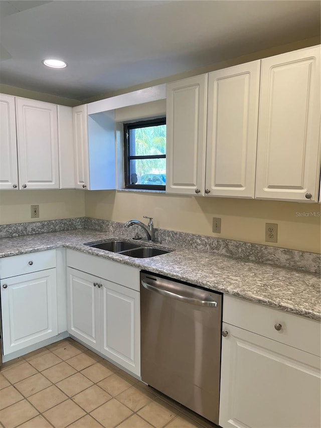 kitchen featuring sink, stainless steel dishwasher, white cabinets, and light tile patterned flooring