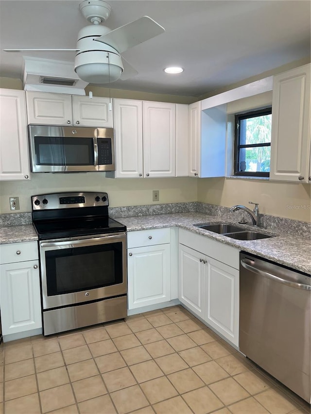 kitchen featuring white cabinetry, appliances with stainless steel finishes, sink, and light tile patterned flooring