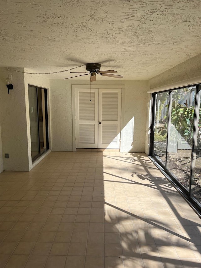 unfurnished sunroom with ceiling fan