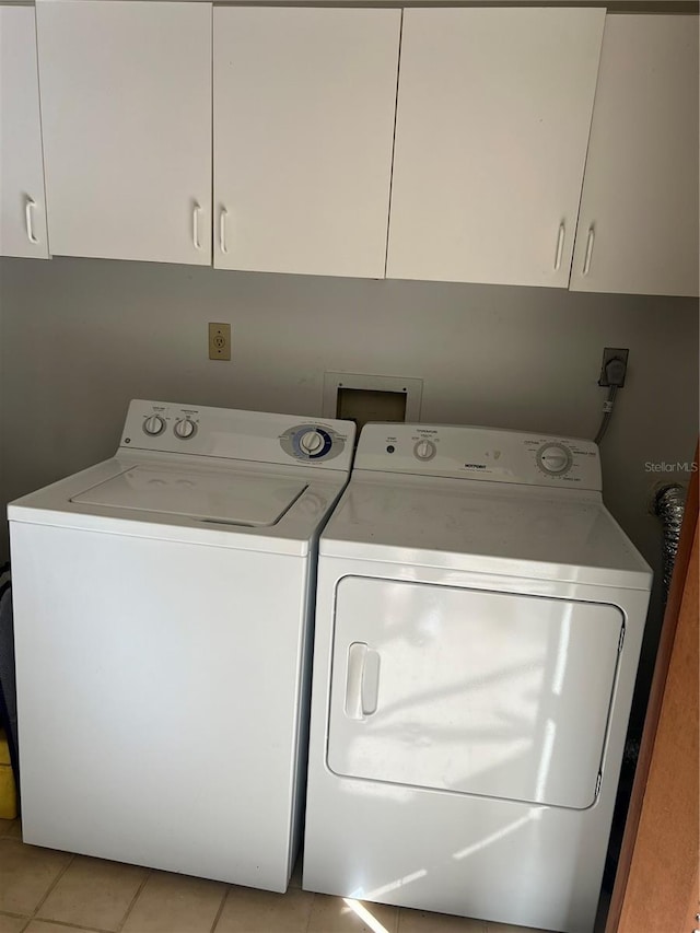 washroom with cabinets, independent washer and dryer, and light tile patterned flooring