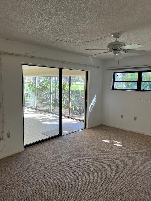 spare room featuring ceiling fan, carpet floors, and a textured ceiling