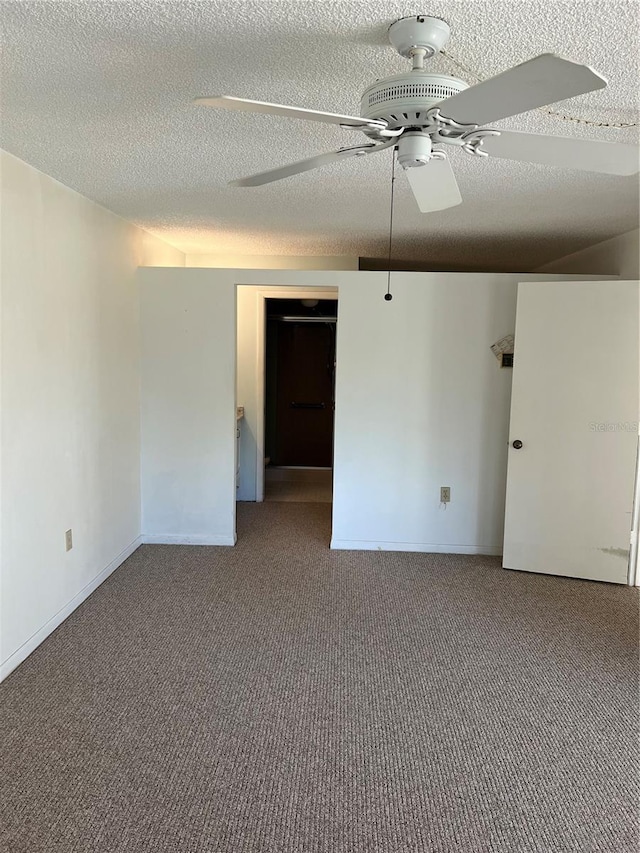 carpeted empty room featuring ceiling fan and a textured ceiling