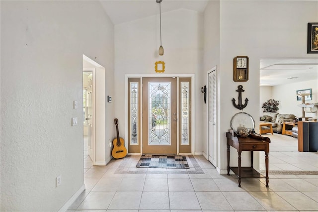 tiled foyer featuring high vaulted ceiling