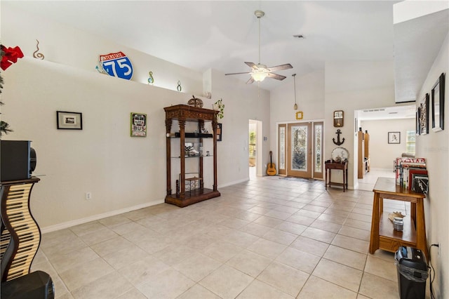 tiled living room featuring ceiling fan and high vaulted ceiling