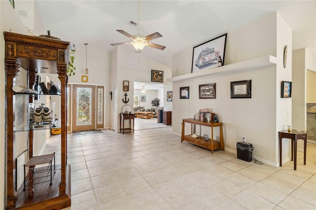 tiled entrance foyer with ceiling fan and high vaulted ceiling